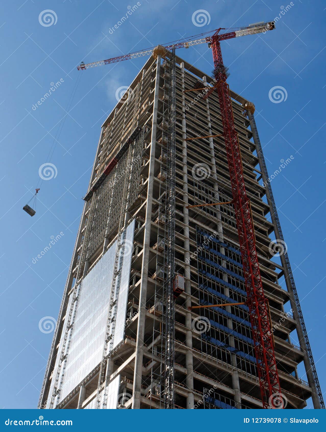 lifting crane hoisting a weight at skyscraper cons