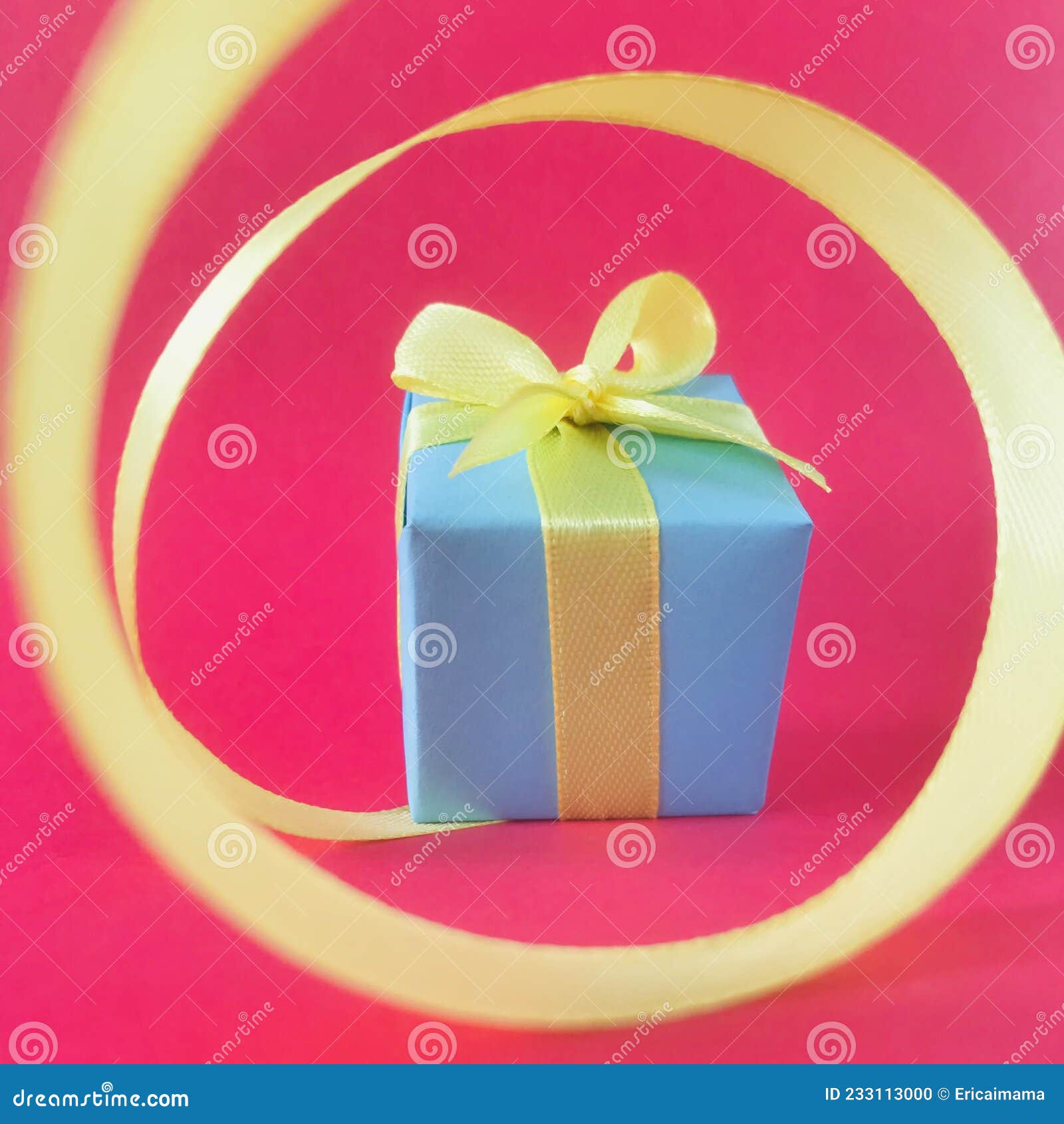 light blue gift box at the end of the spiral yellow ribbon, red background. square.