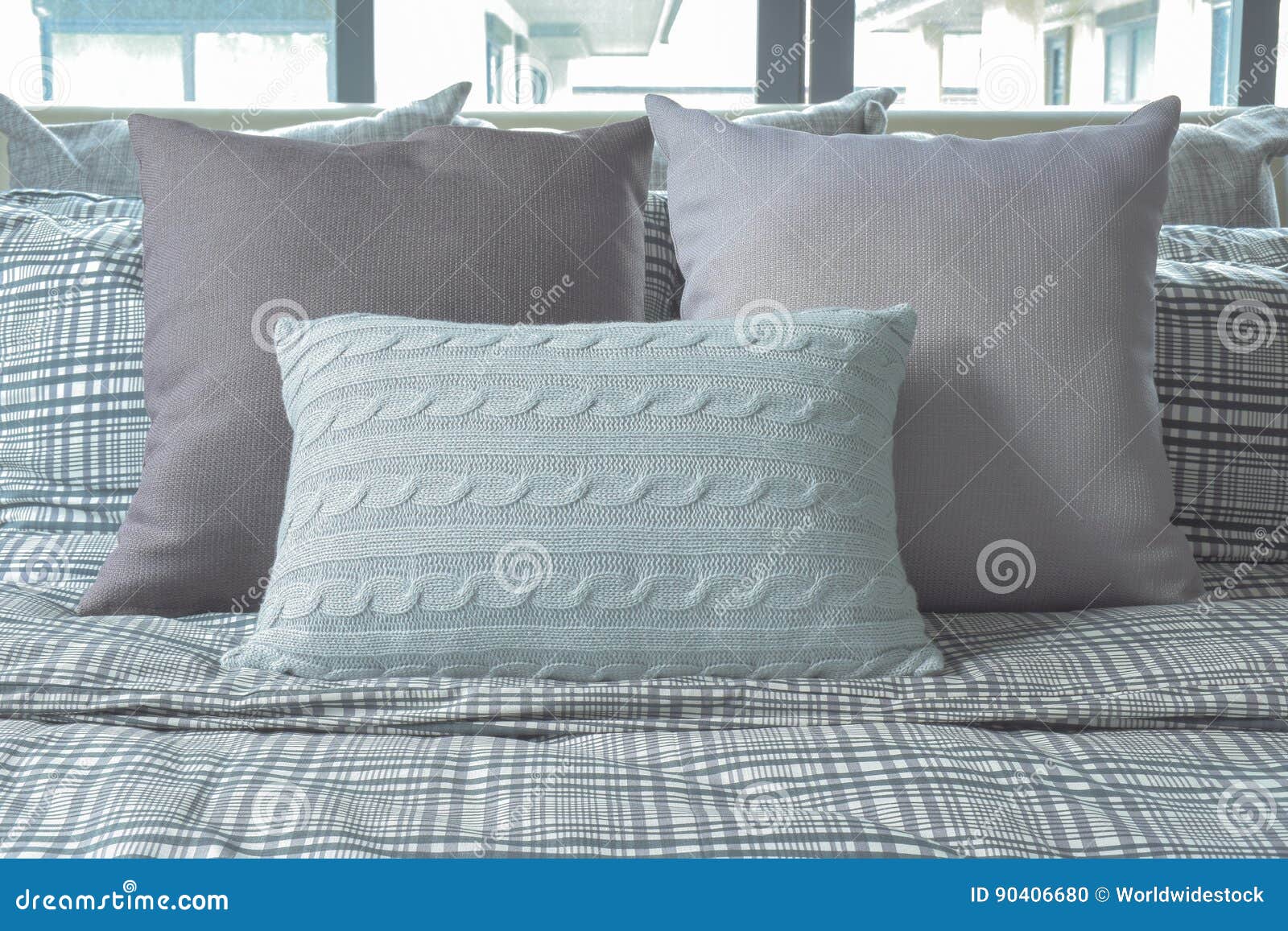 Light Blue and Gray Pillows on Cross Pattern Bedding Stock Photo