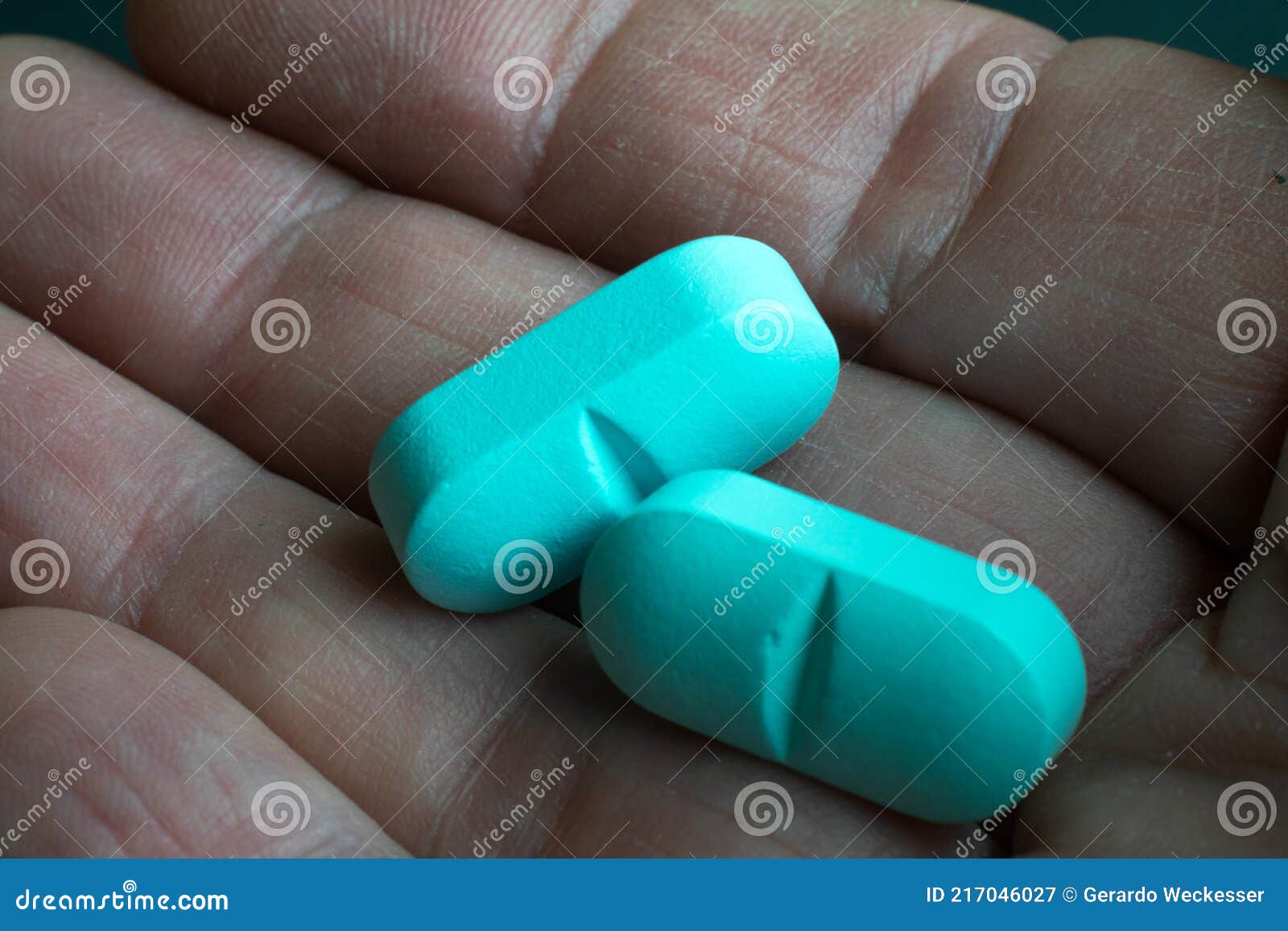 Light blue pill on hand stock image. Image of medicine 217046027