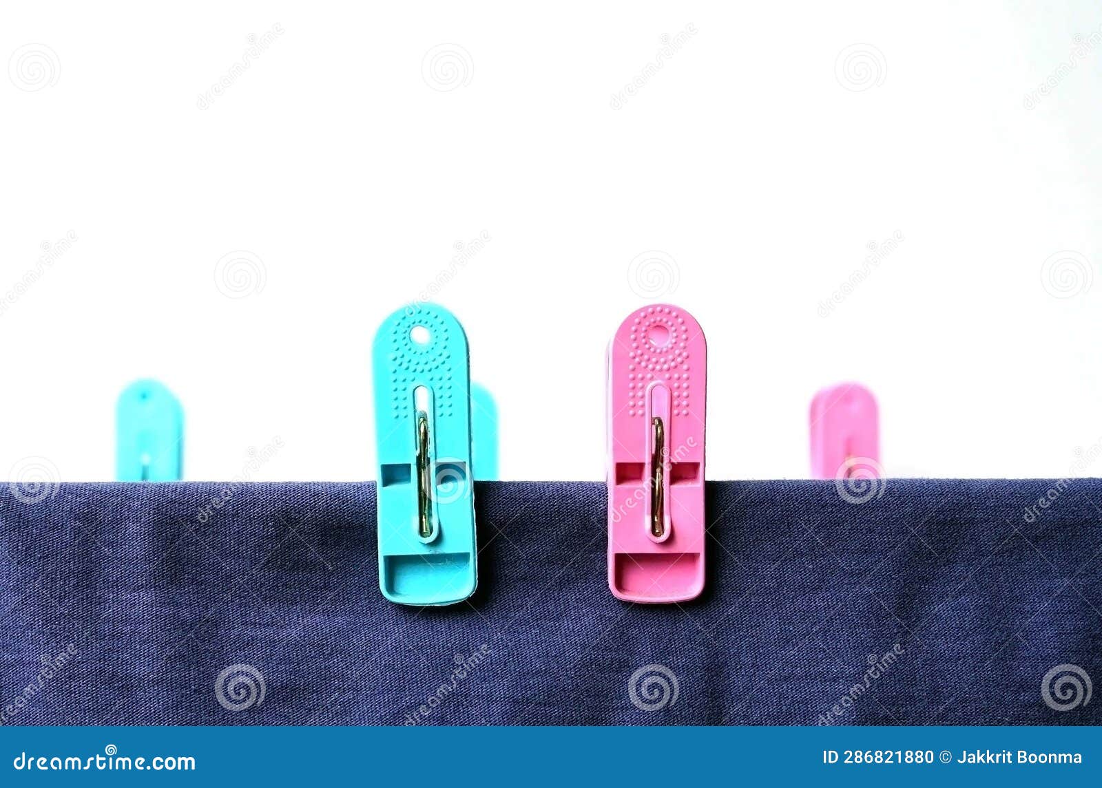 A Light Blue and Pink Clothespins with a Blue Clothes on a Clothesline