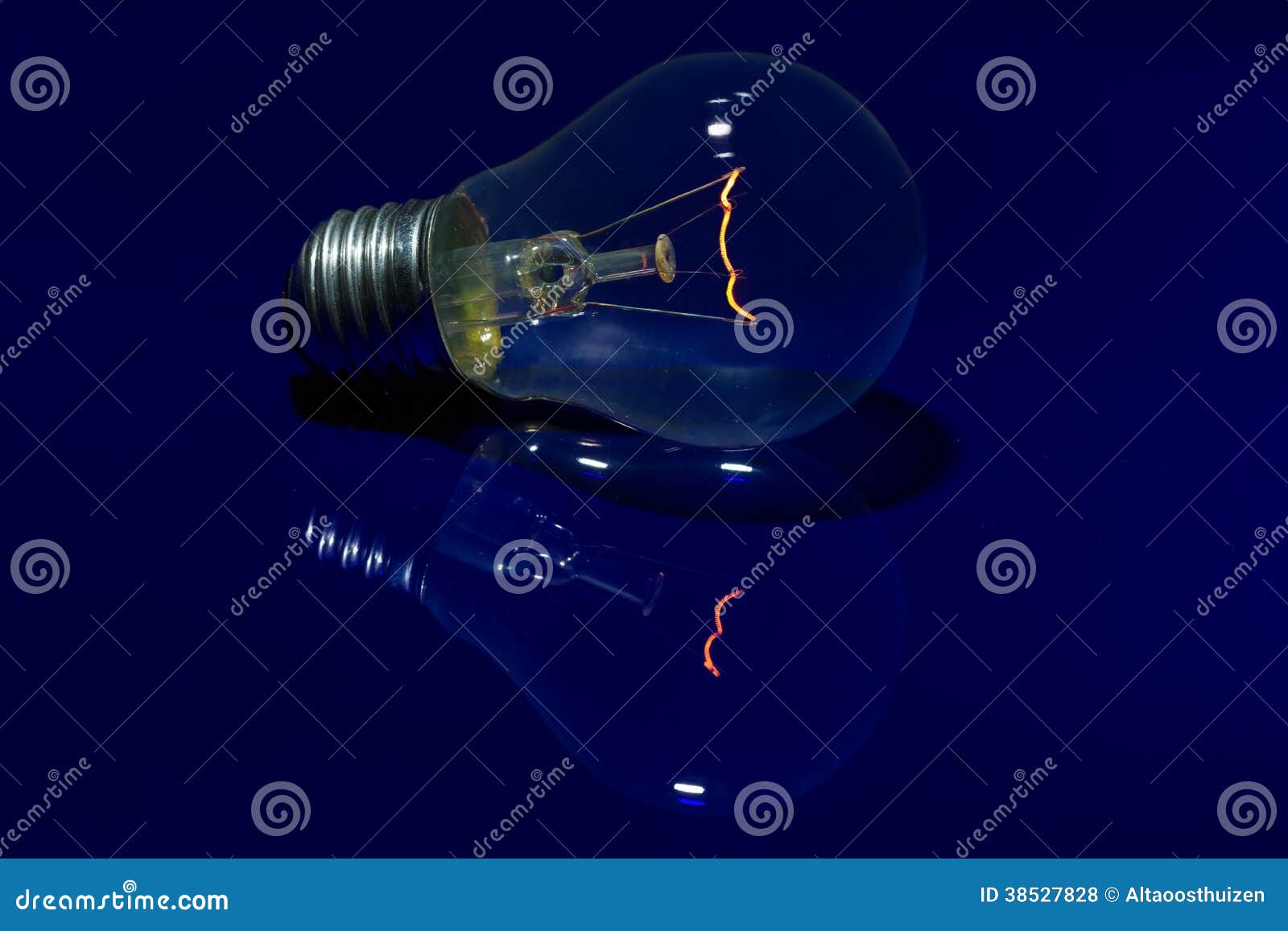 Light Bulb with Burning Filament Lay on Blue Surface with Reflection Stock Photo Image of lamp