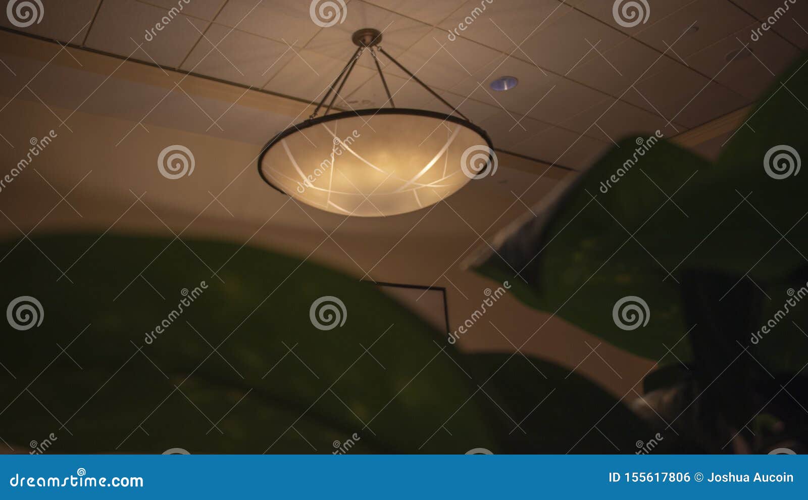 A Light Fixture Dimly Lit Hanging Off The Ceiling Above