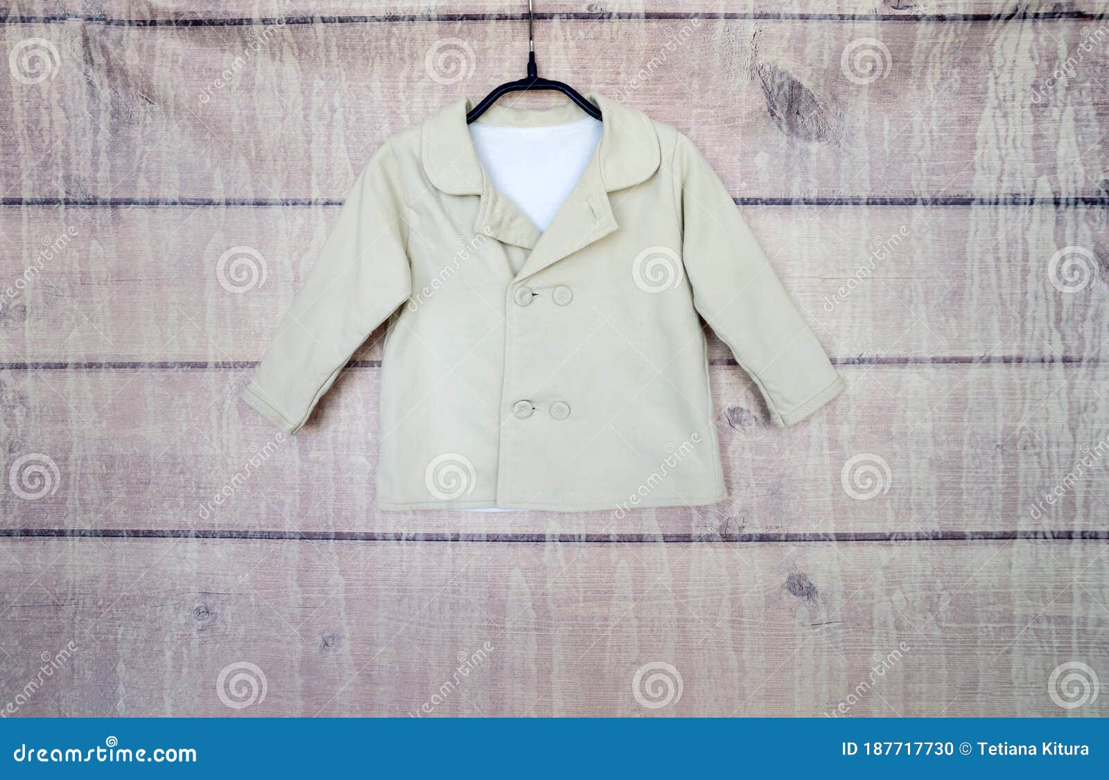 Light Jacket on a Hanger on a Wooden Background. Stock Photo - Image of