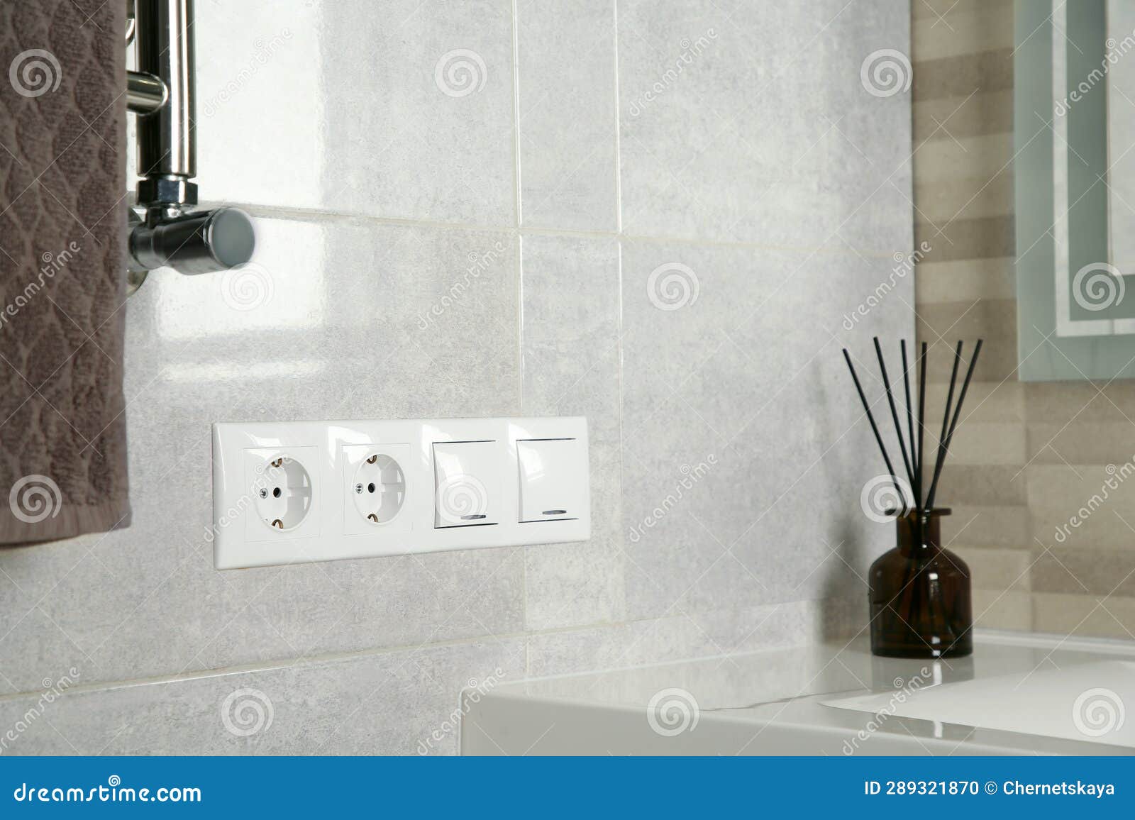 Light Switches and Power Sockets on Light Grey Wall in Bathroom. Space