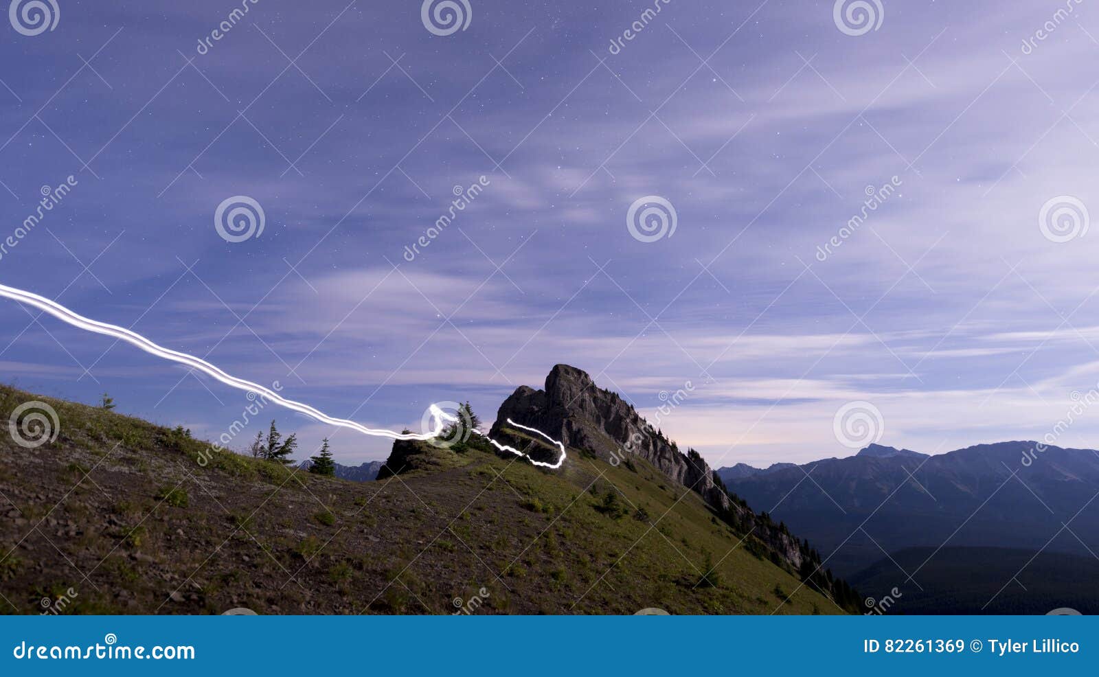 Light Trail Running Along Ridge of Mountain at Night Stock Image