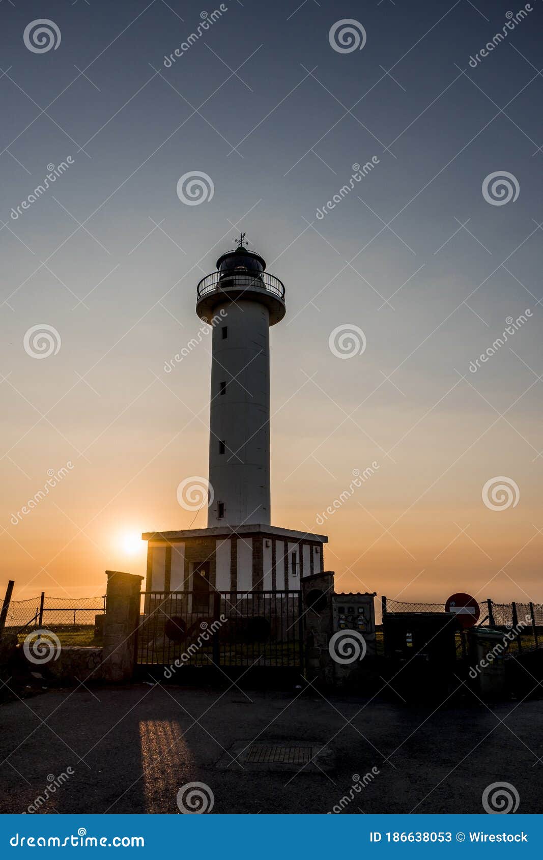 lighthouse of lastres at sunset captured in the town of luces, spain