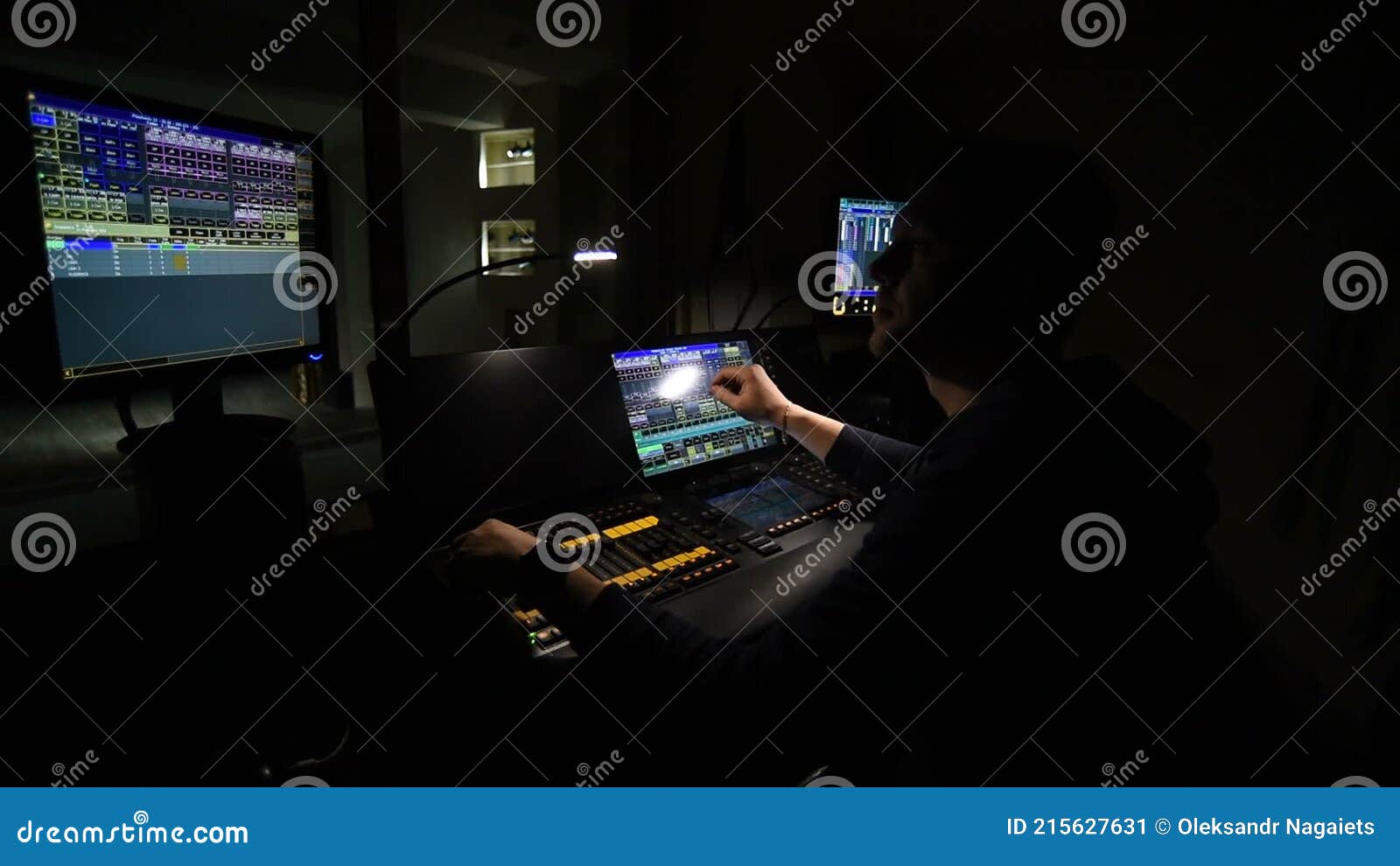 Lighting Engineer Works on a Light Console in His Office Overlooking