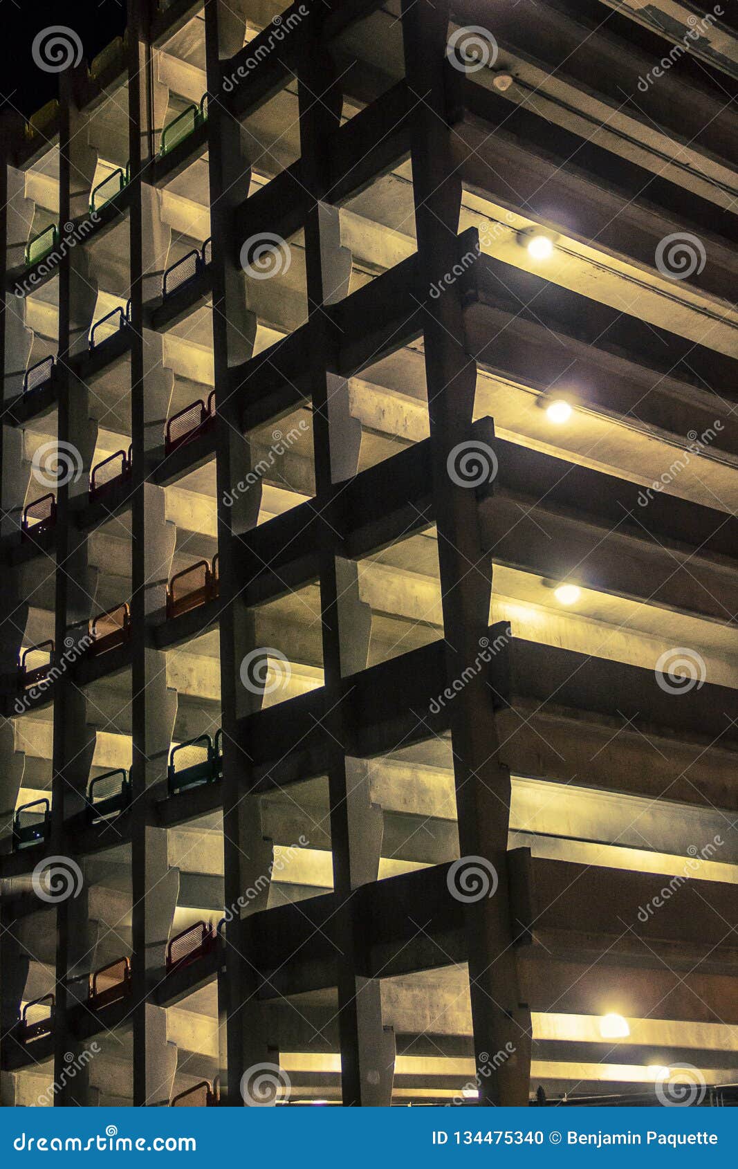 Lights Glowing from a Parking Garage at Night Time Stock Photo Image