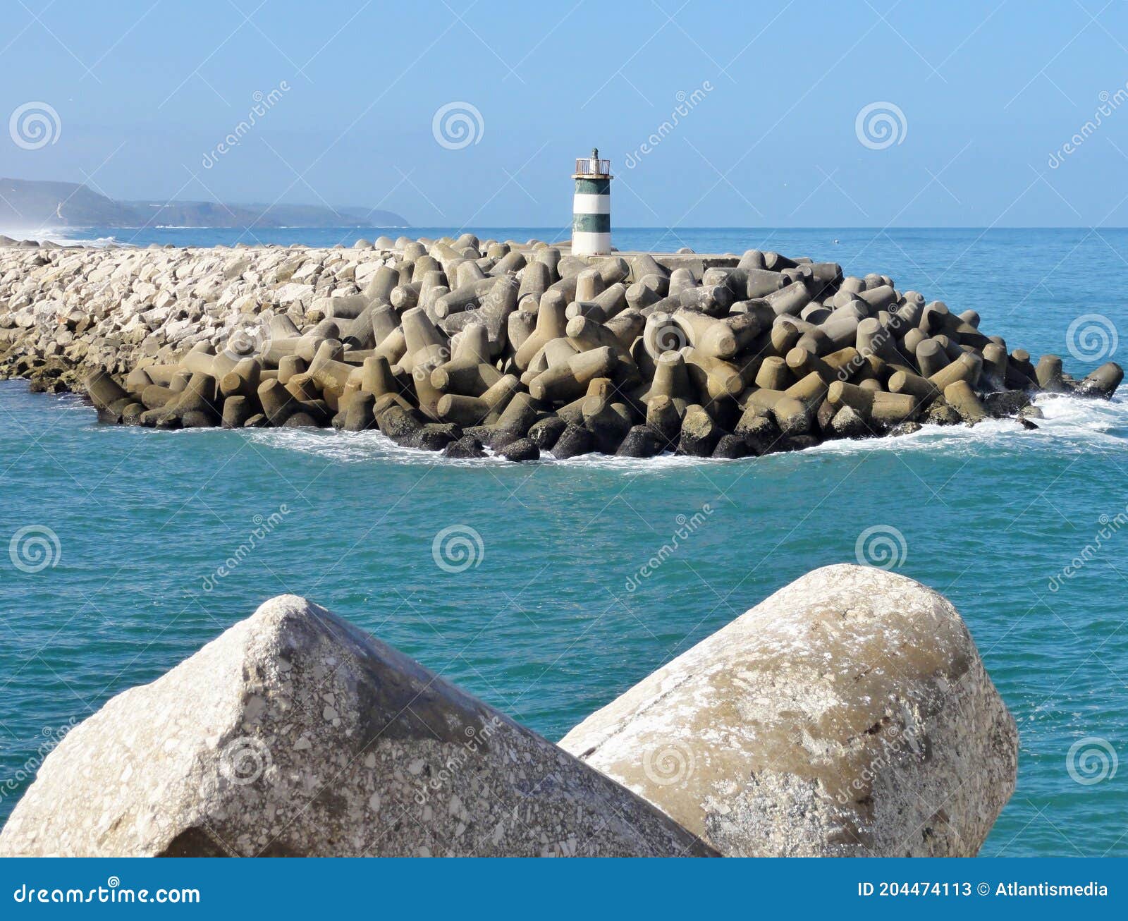 lighttower and harbor entrance in nazare, centro - portugal