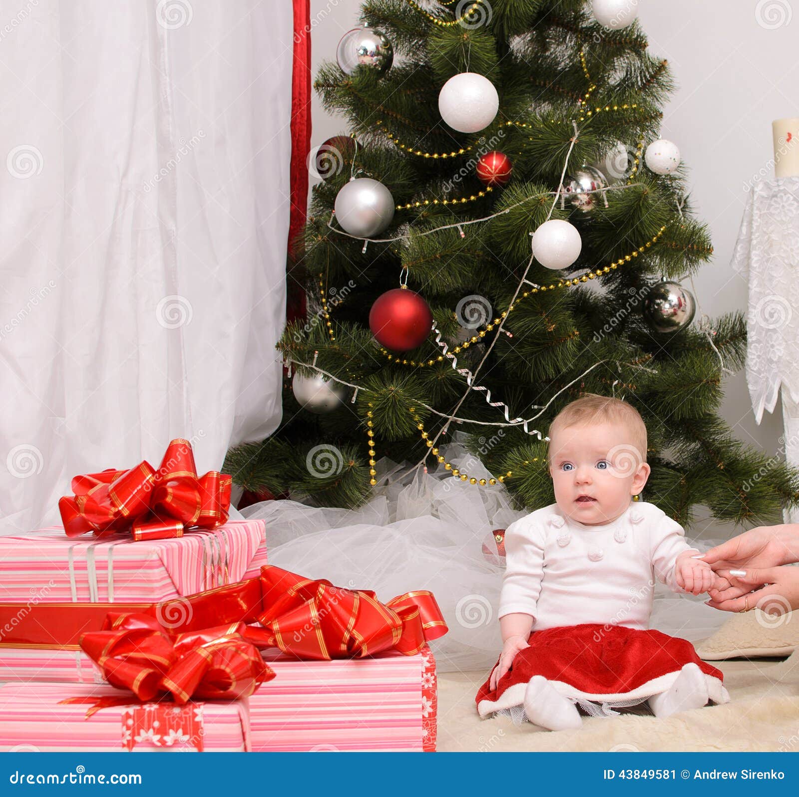Lilla barnet behandla som ett barn i inre jul. Lilla barnet behandla som ett barn i julinre som sitter nära julgranen
