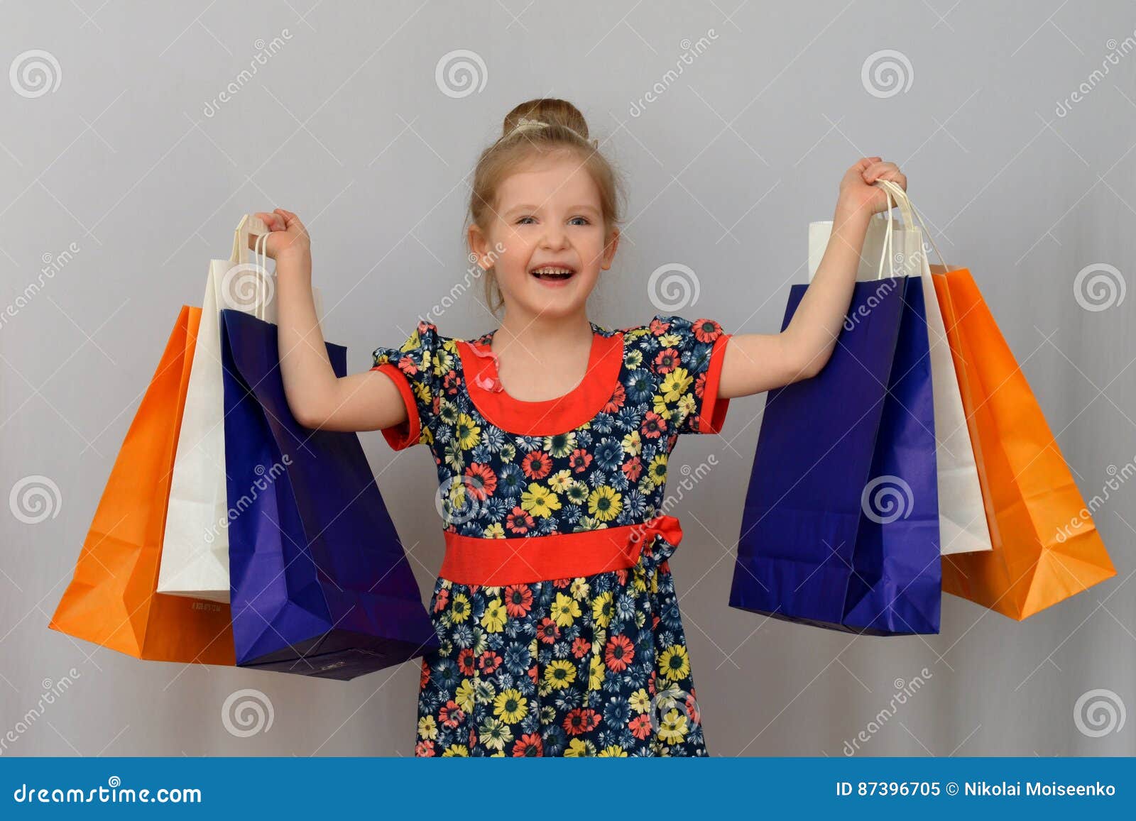 Lilla flickan, köparen rymmer de kulöra shoppingpåsarna