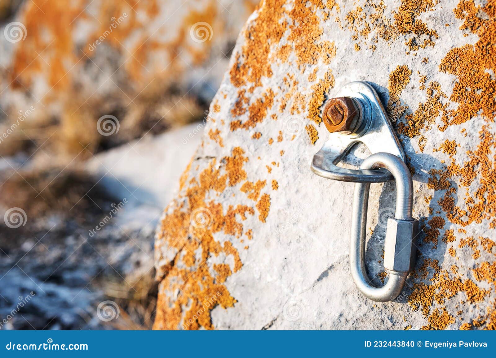 ÃÂ¡limbing carabiner hook and trigger device in stone. carabiner for mountaineering on rocky background.