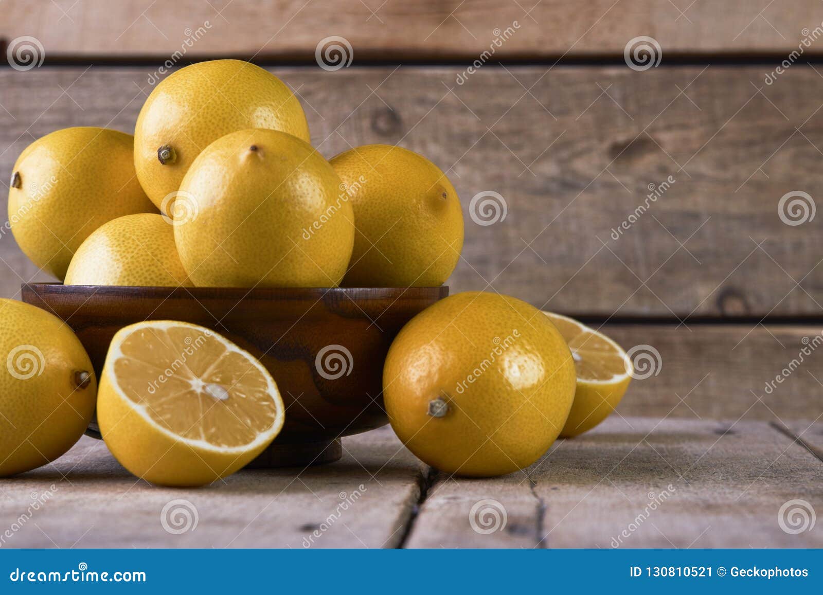 Limoni Freschi in Una Ciotola Di Legno Su Fondo Di Legno Con Lo