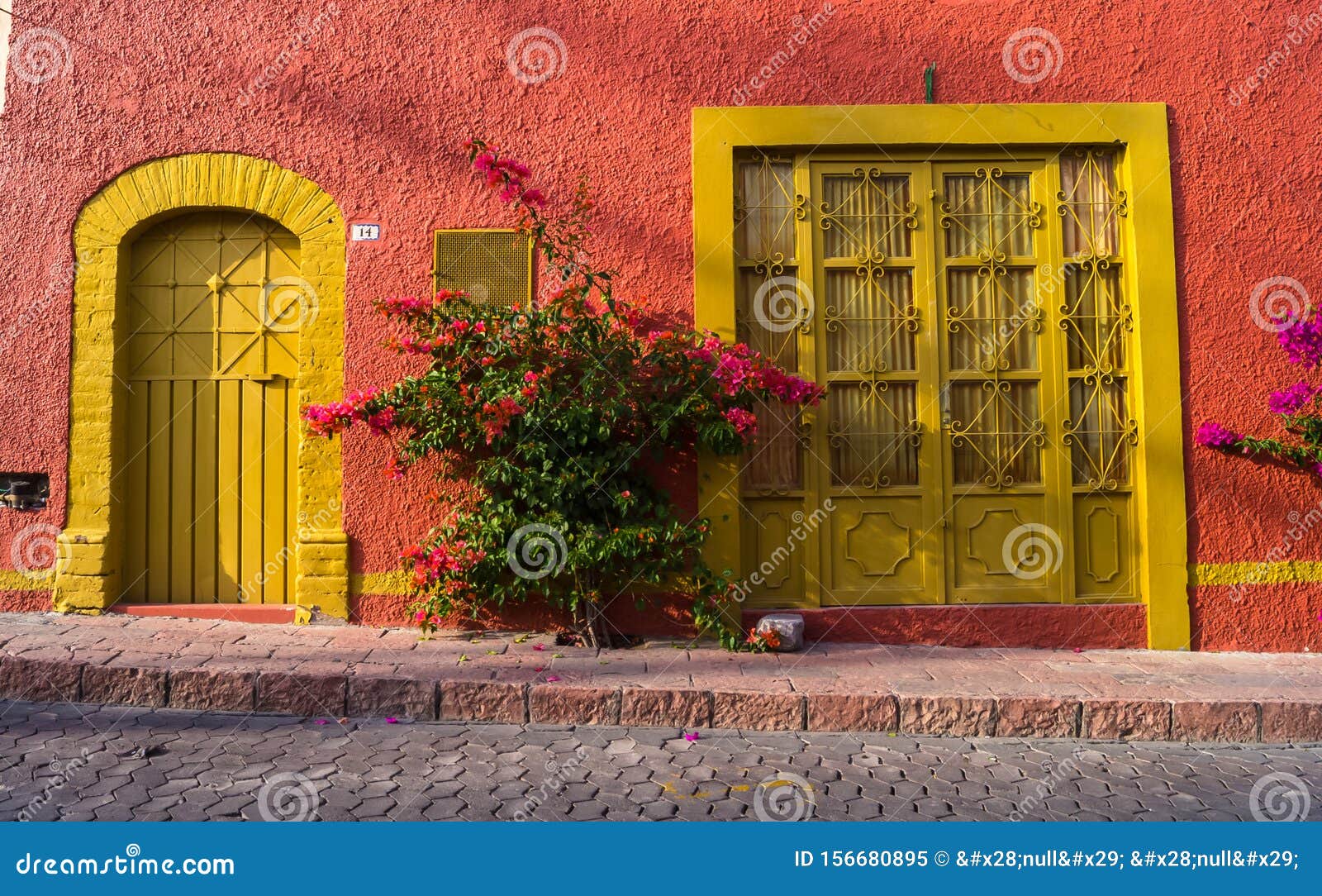 Uma casa rosa com um exterior rosa e uma porta rosa.