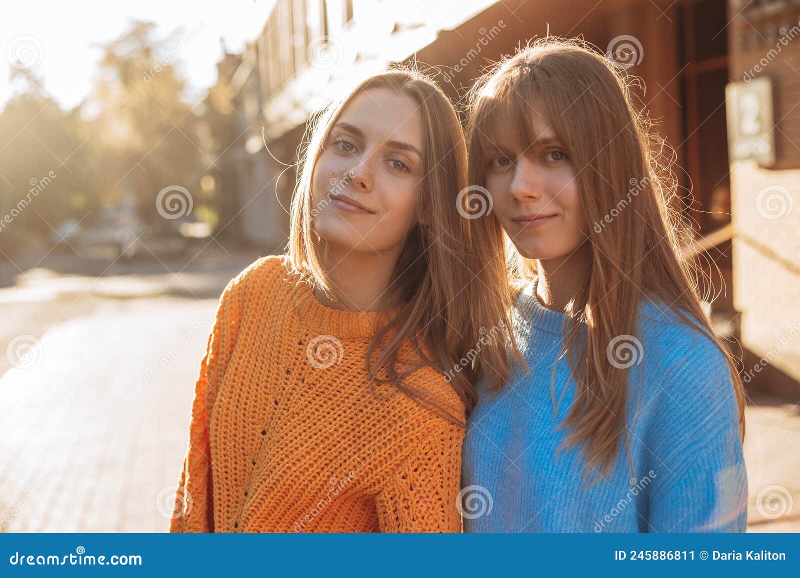 Meninas bonitas esticando o cabelo e olhando para a câmera