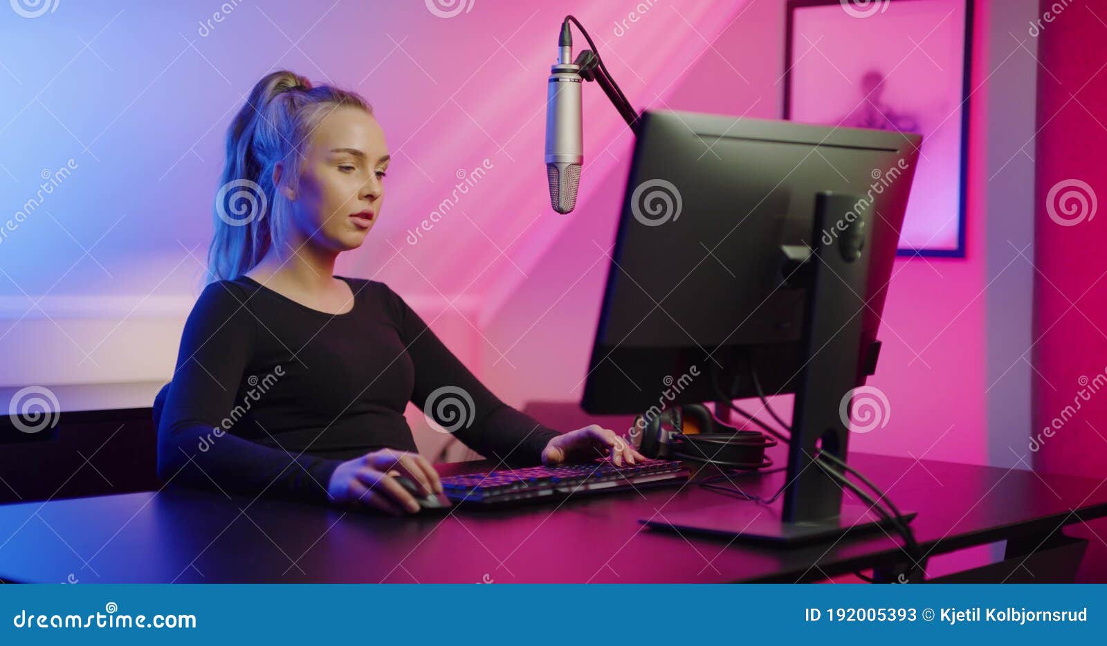 Vista por cima do ombro da garota jogadora usando a configuração de jogos  para pc relaxando jogando videogame de ação online multiplayer falando  usando fone de ouvido. mulher transmitindo um jogo de