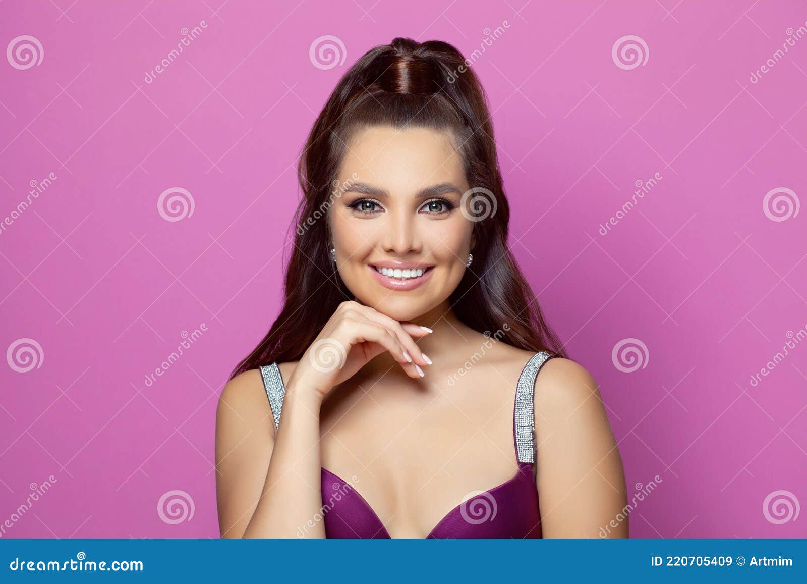 Retrato de uma jovem mulher bonita com noite maquiagem tocando seu