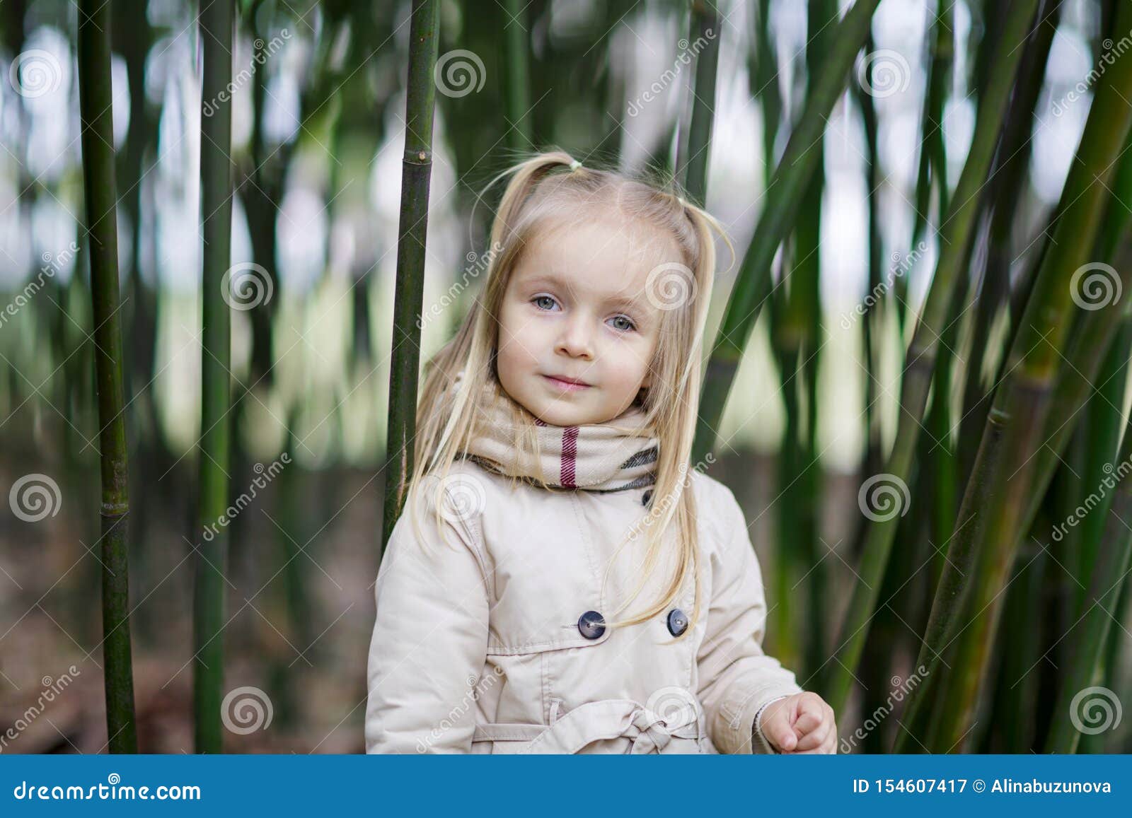 Linda Menina De Cabelos Loiros Em Uma Floresta De Bambu E Tremendo