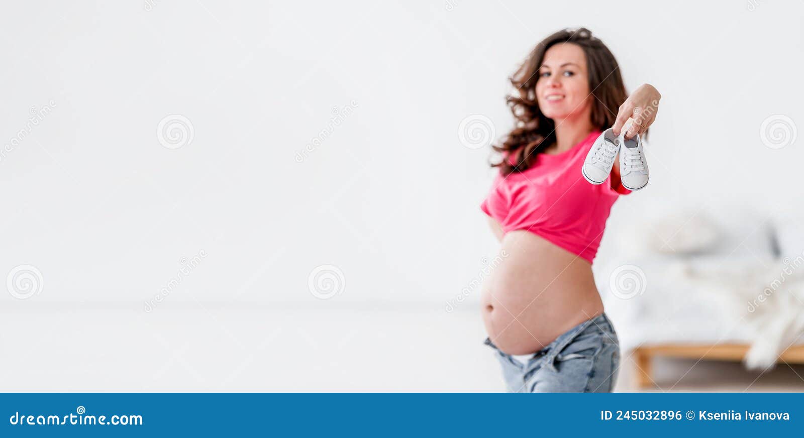 Linda Mujer Joven Embarazada Con Ropa Moderna En Habitación Blanca. El  Concepto De Maternidad Y Embarazo Foto de archivo - Imagen de casero,  bandera: 245032896