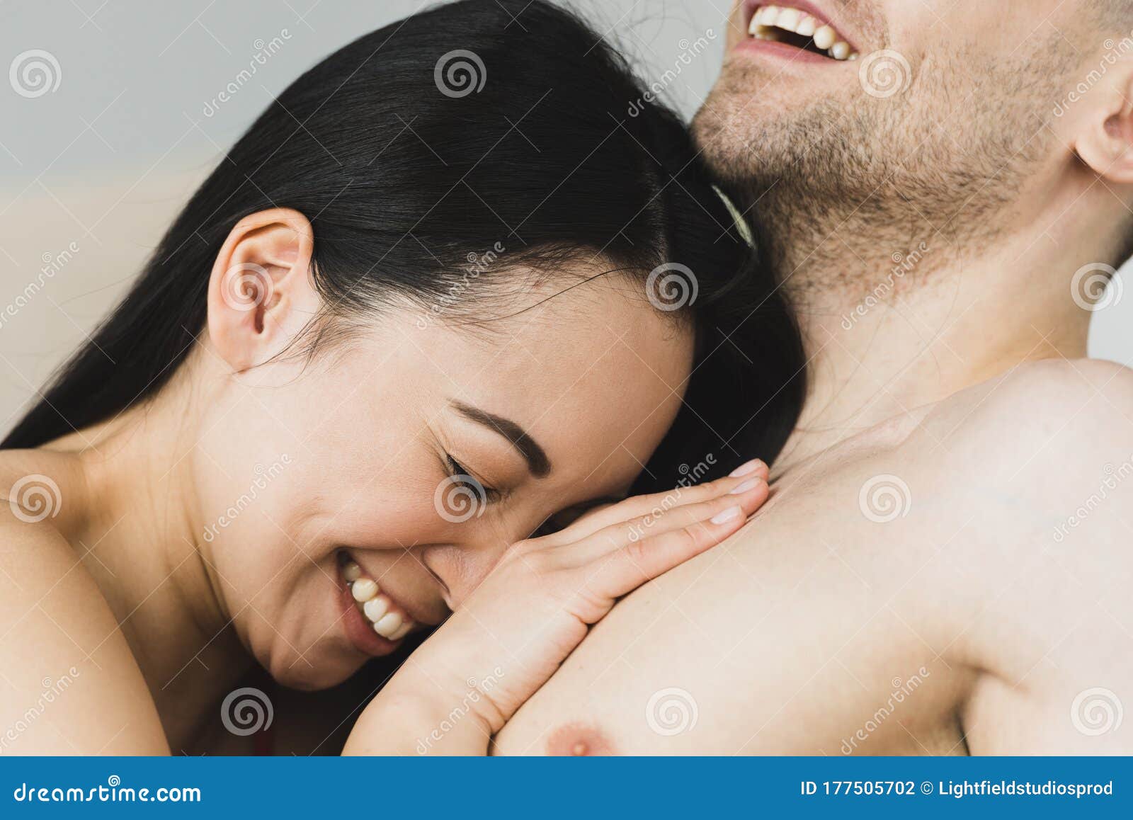 Linda Mulher Asiática Deitada Nos Seios De Namorado Sorridente Foto de Stock