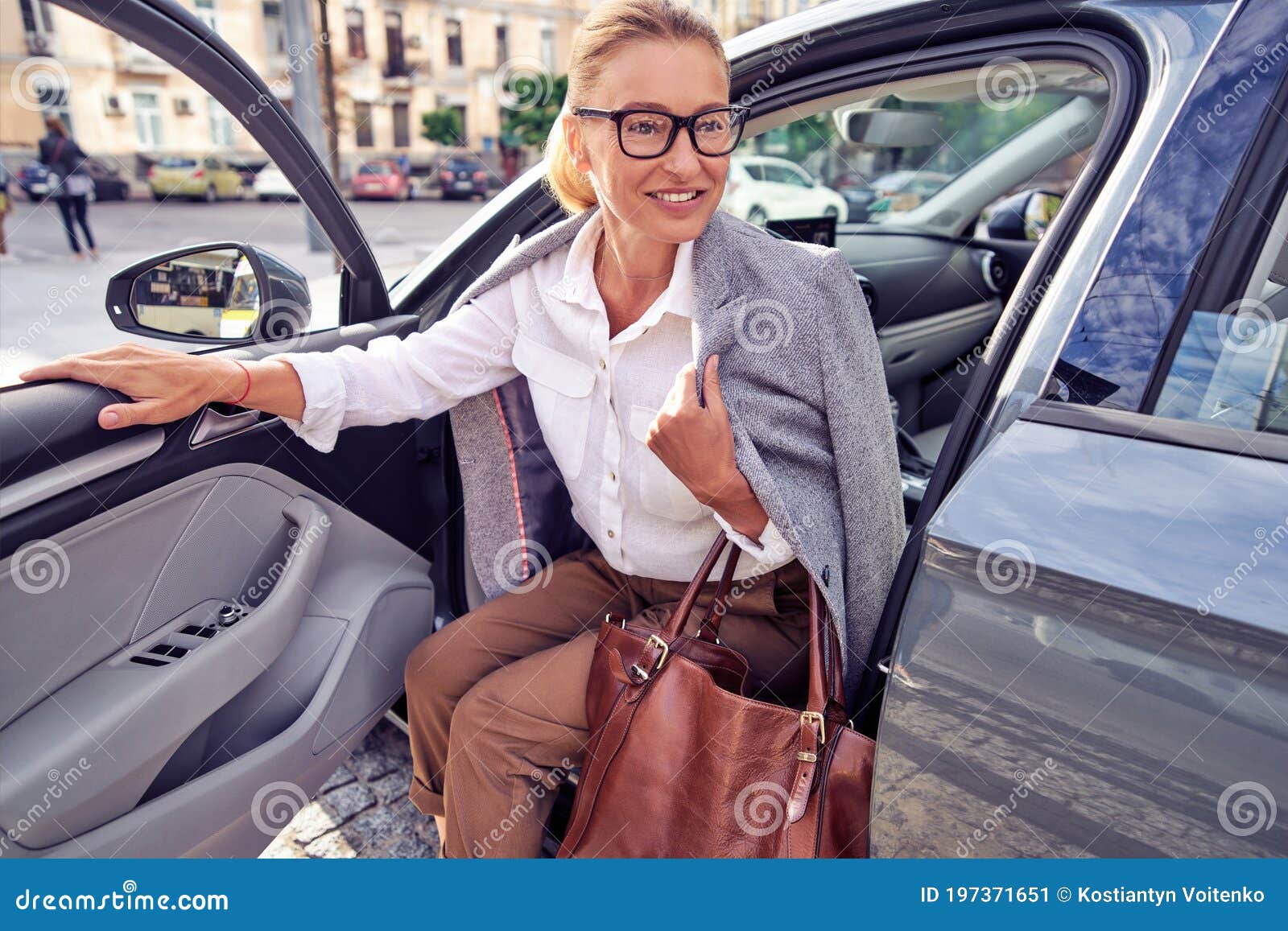 Linda Mulher De Meia-idade Chegou Ao Trabalho, Ela Está Saindo Do Seu Carro Moderno E Sorrindo Imagem de Stock