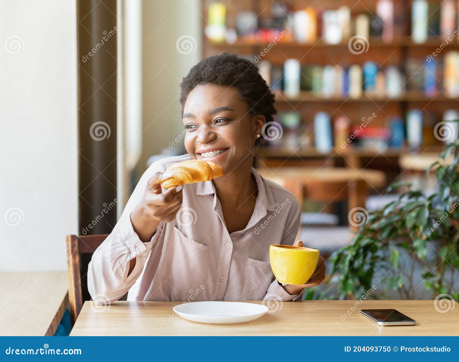 Linda Negra Bebendo Café Aromático E Comendo Croissant Saboroso Olhando  Pela Janela No Café Confortável Da Cidade Foto de Stock - Imagem de  pastelaria, bonito: 204093750