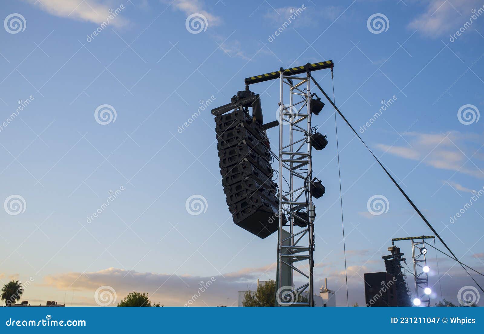 line array speaker system hanging from pole during daylight performance