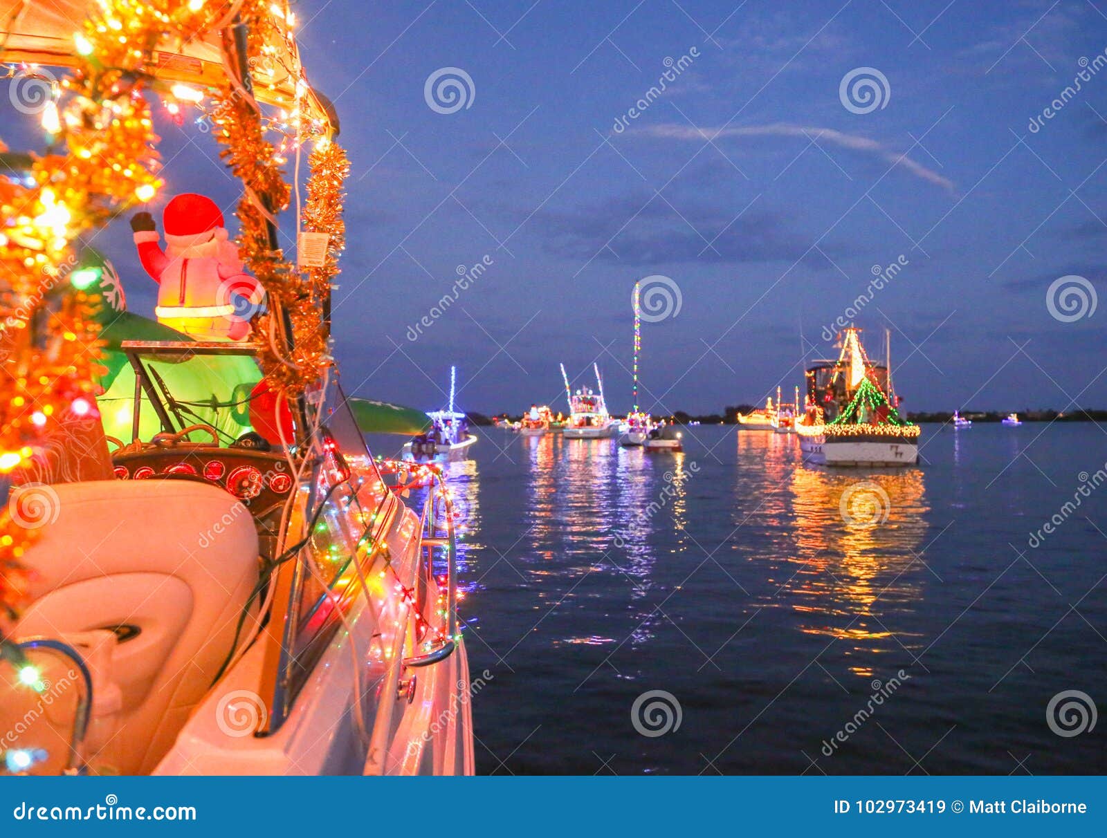 a line of decorated boats participate in a florida holiday boat