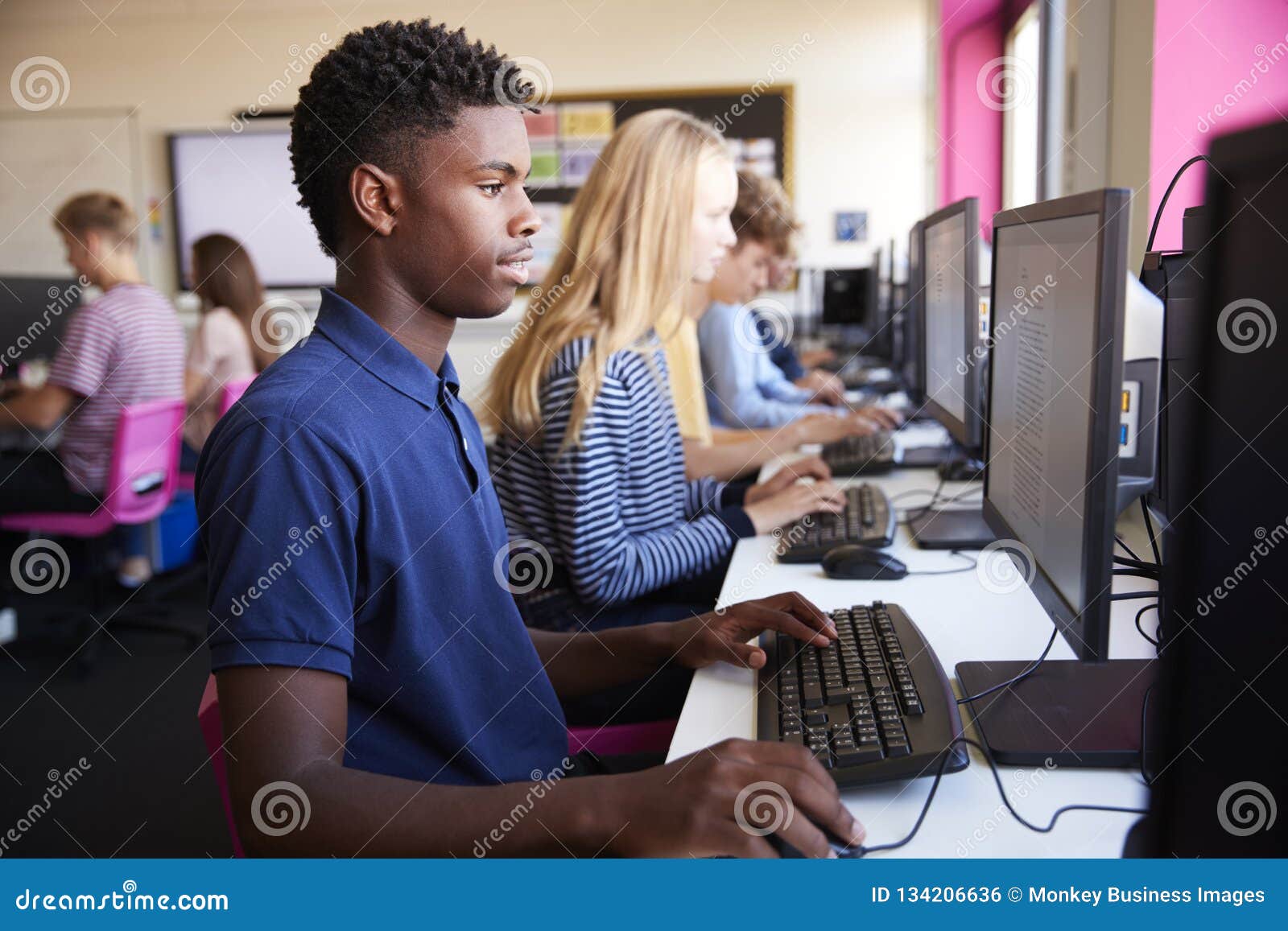 line of teenage high school students studying in computer class