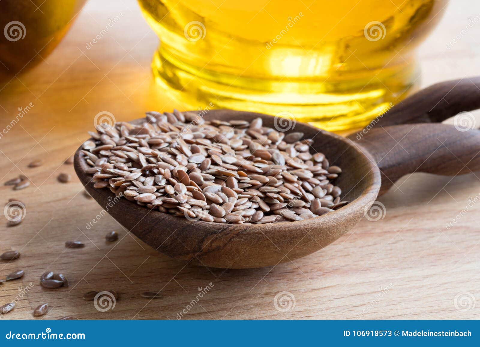 Linseed on a Wooden Spoon, with Flaxseed Oil in the Background Stock