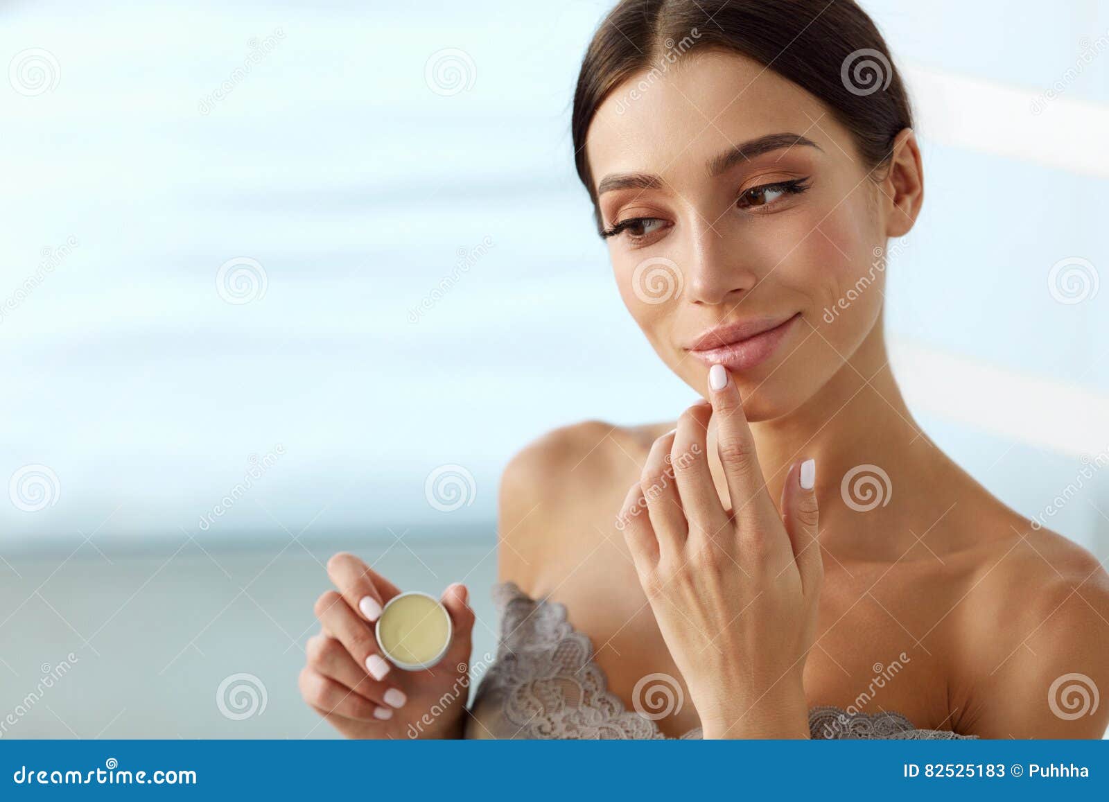 lips skin care. woman with beauty face applying lip balm on