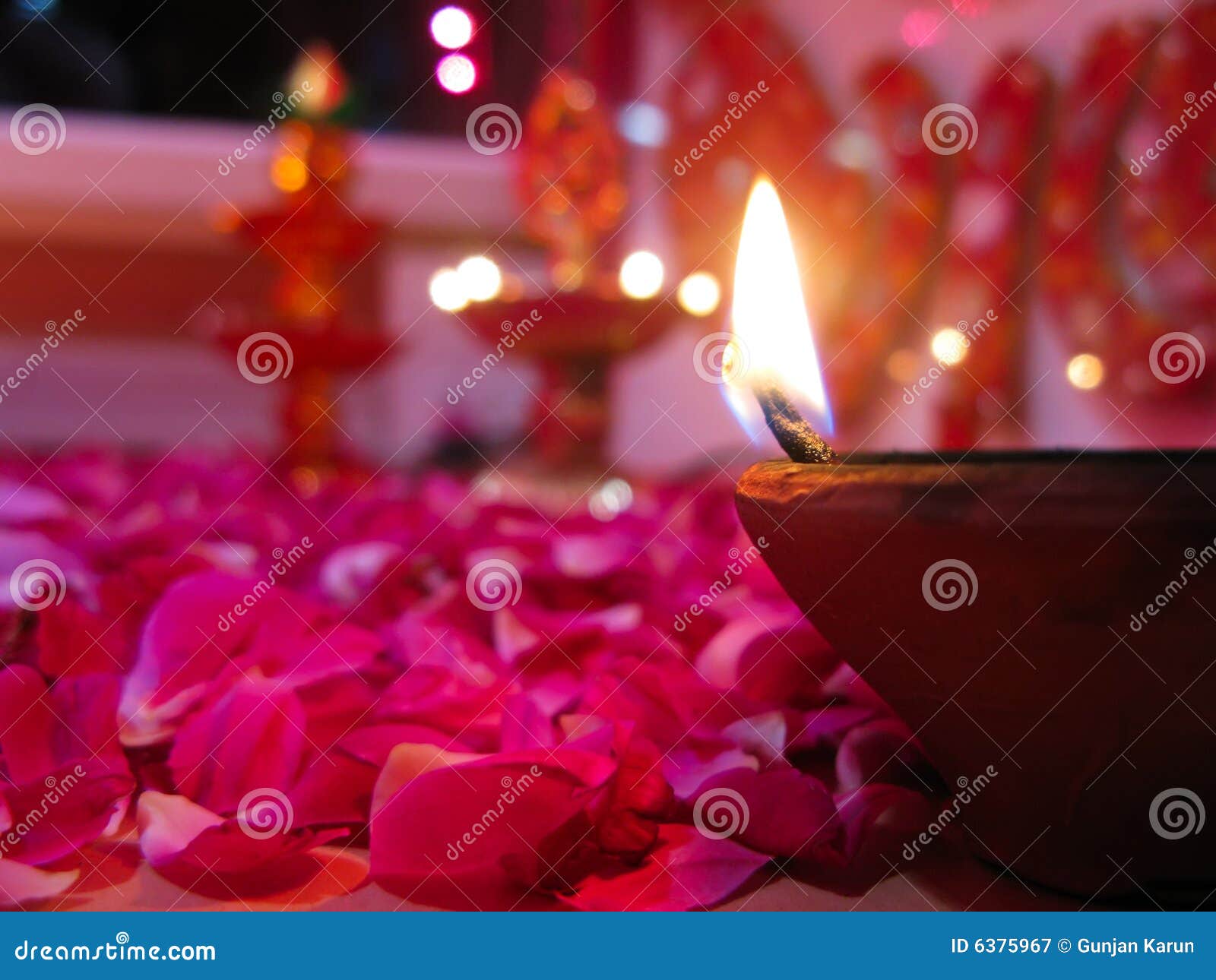 a lit diya on bed of roses