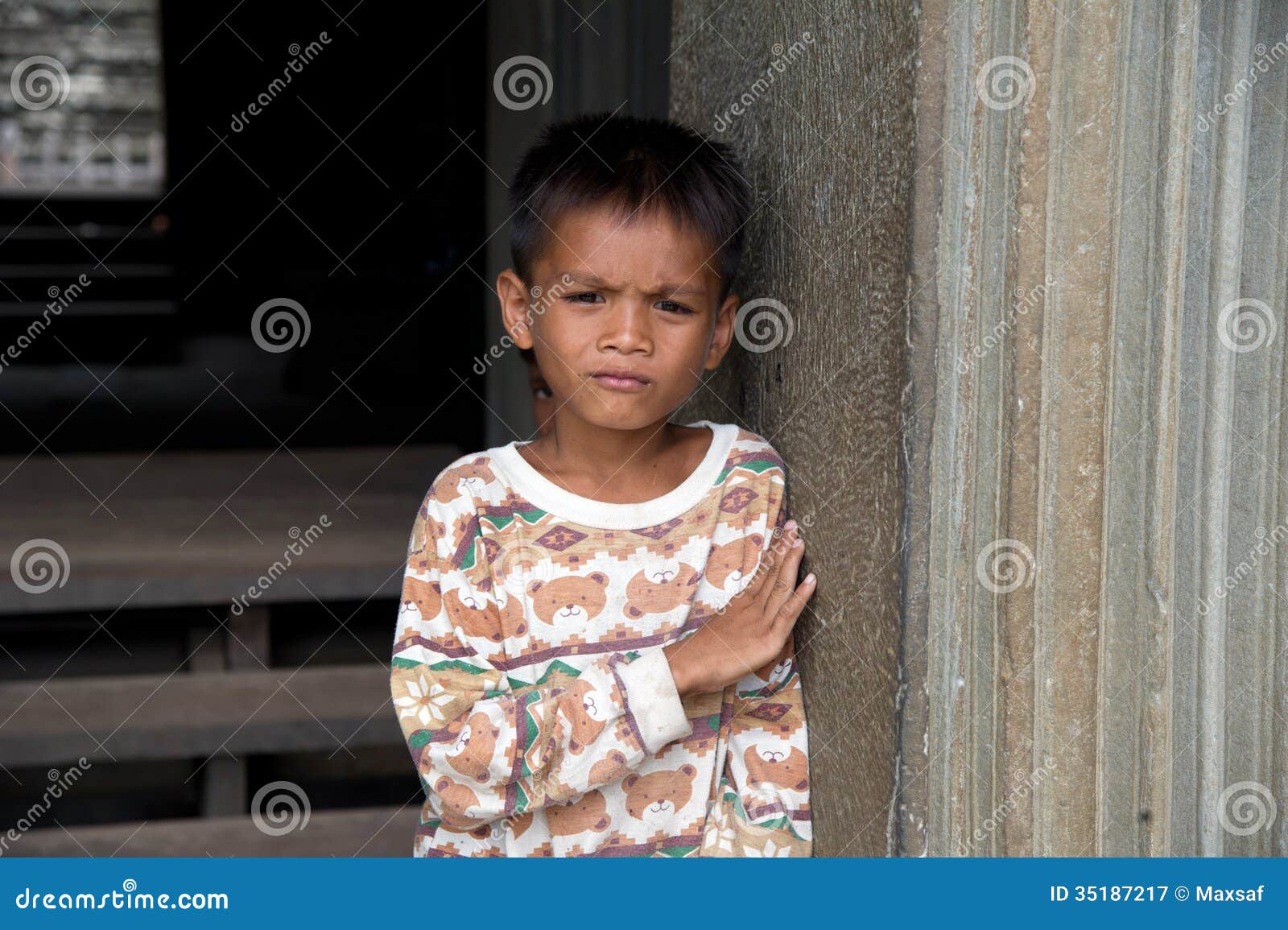 Little Asian Boy With Bottle Of Water Posing In Angkor Wat 