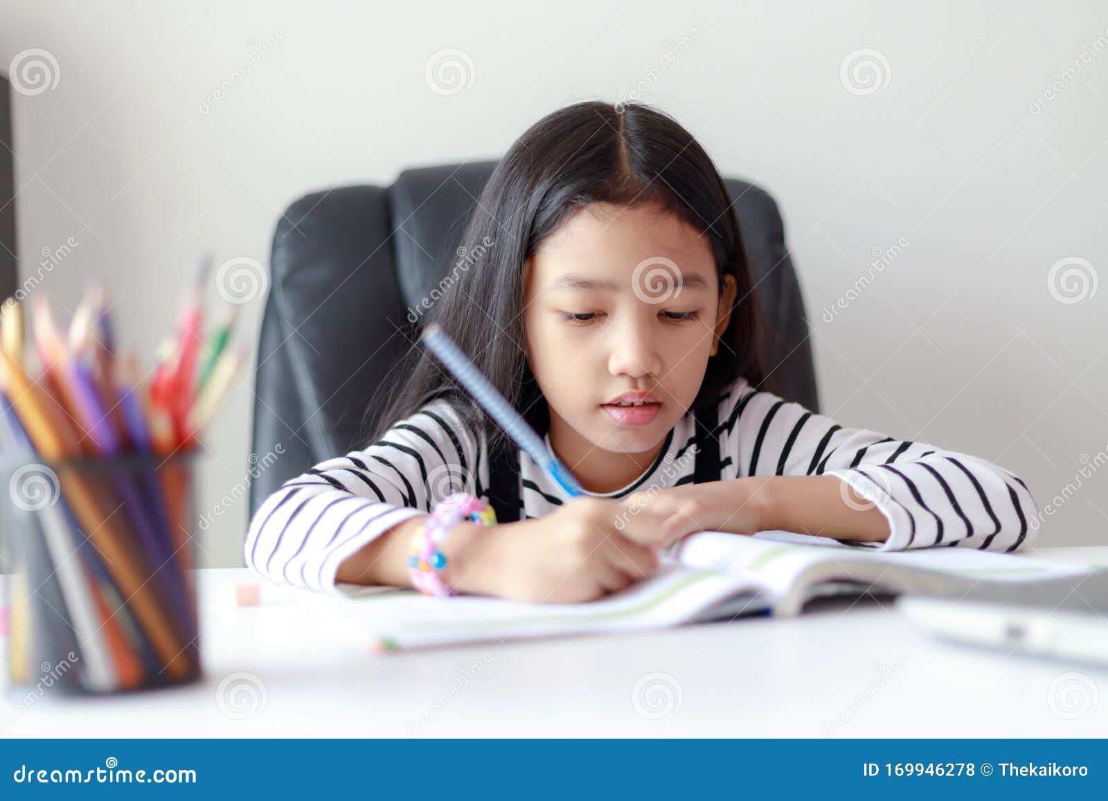 Little Asian Girl Doing Homework For Self Learning And Education