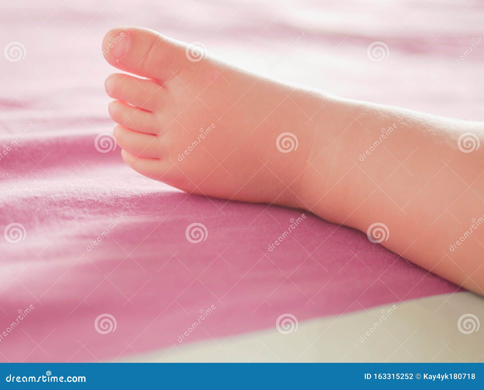 little baby feet. theres nothing quite so sweet as tiny little baby feet. little baby boy on bed. close up. space for copy