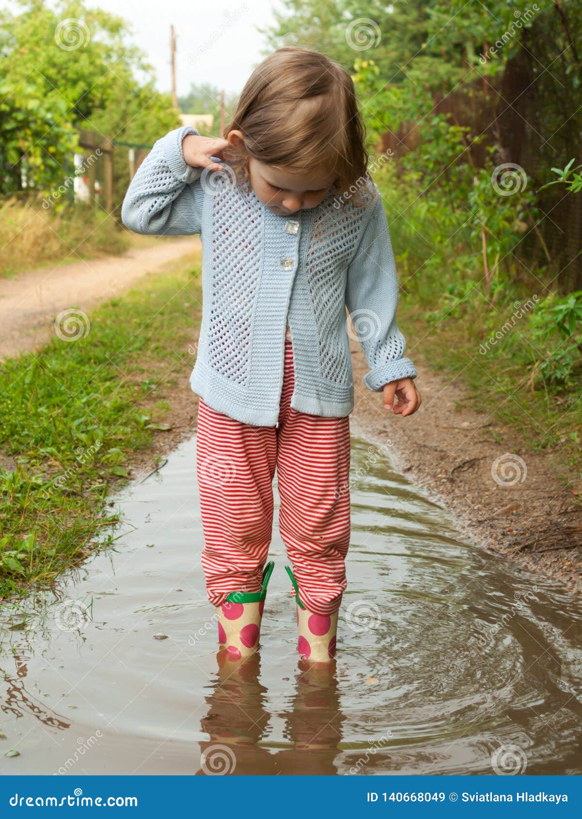 A Little Baby Girl in Rubber Boots Exploring the World and the Depth of ...