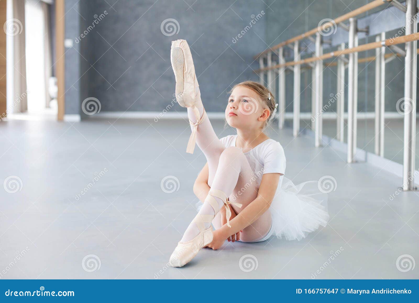 Little Ballerina is Trying on Pointe Shoes in Ballet Class. Cute Child is Sitting on Floor Under Barre Stock Image - Image of class, people: 166757647