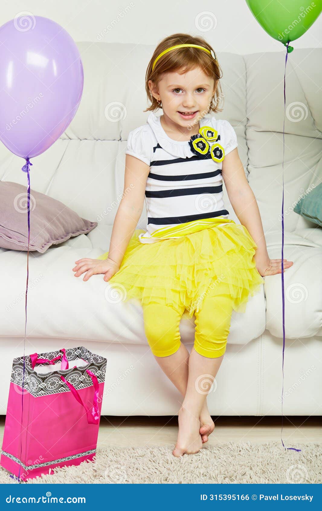little barefooted girl sits on big sofa in room