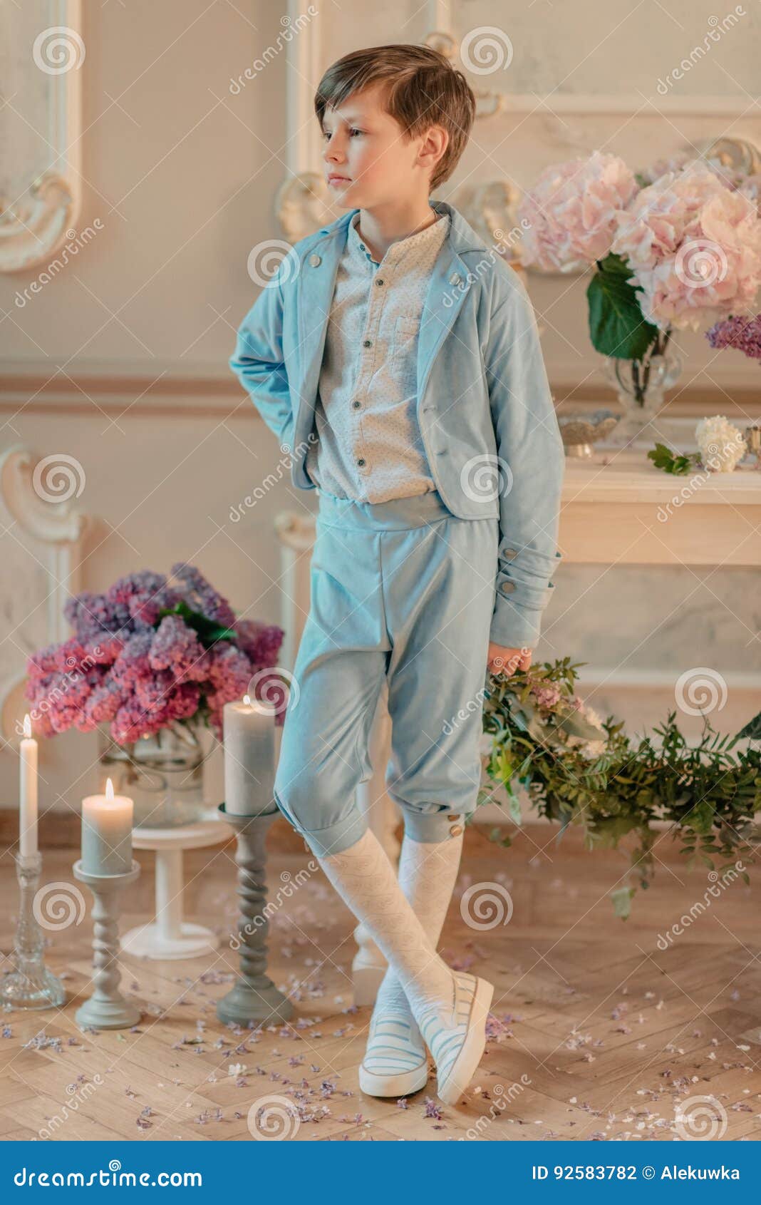 The Little Boy in the Blue Suit in the Studio with Flowers Stock Photo