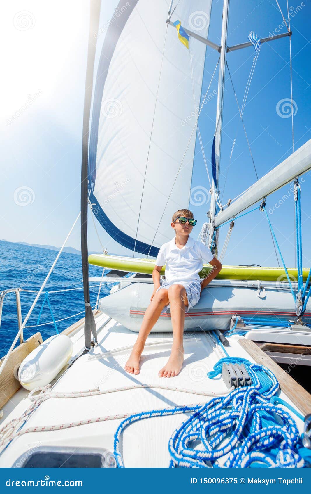 little boy on board of sailing yacht on summer cruise. travel adventure, yachting with child on family vacation.