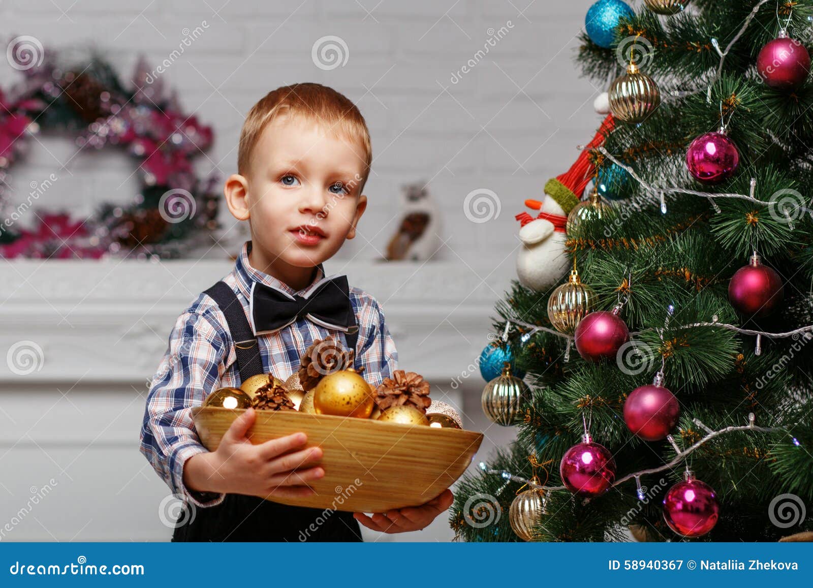 Little Boy Decorates a Christmas Tree in the Interior with Chris Stock