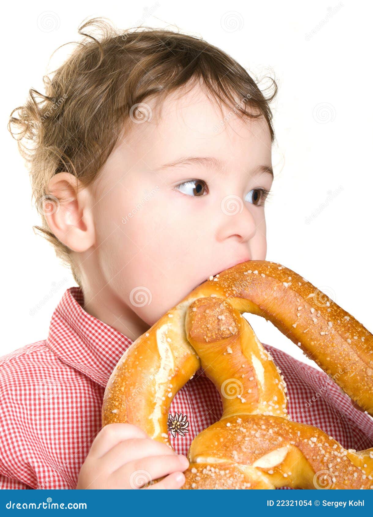 The Little Boy is Eating a Bagel. Stock Photo Image of isolated, face