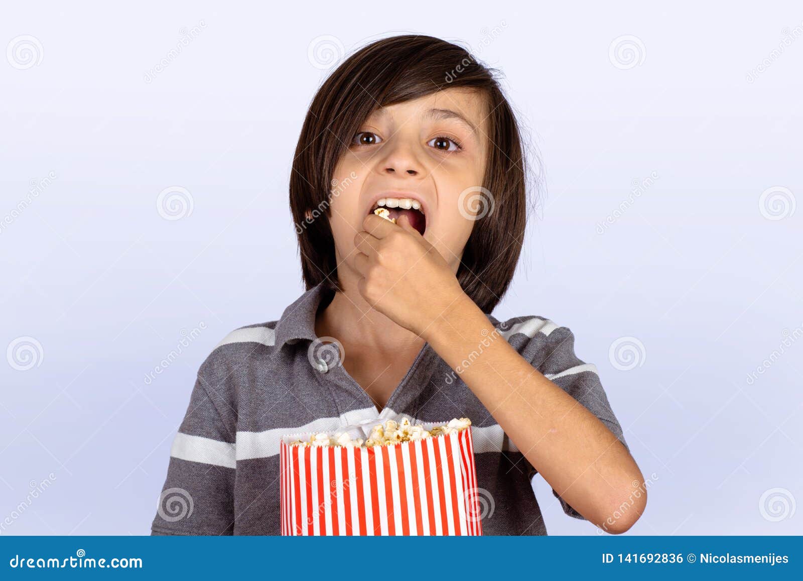 Little boy eating popcorn stock photo. Image of hold 141692836