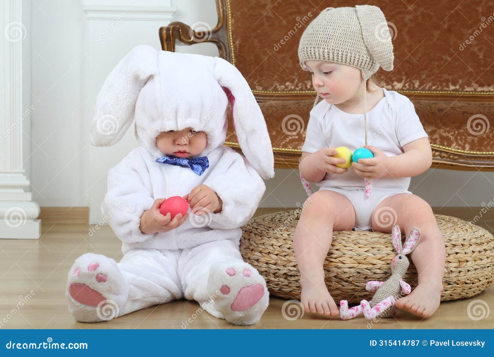 little boy and girl in costumes bunny sitting on