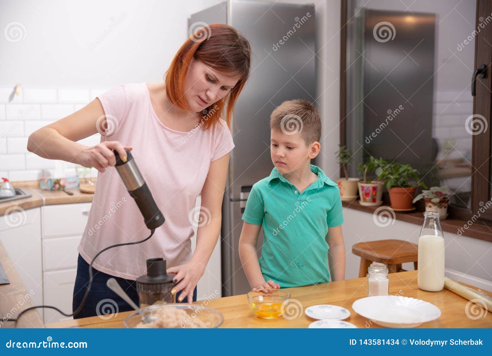 Little Boy Helping His Mother With The Cooking In The Kitchen Stock