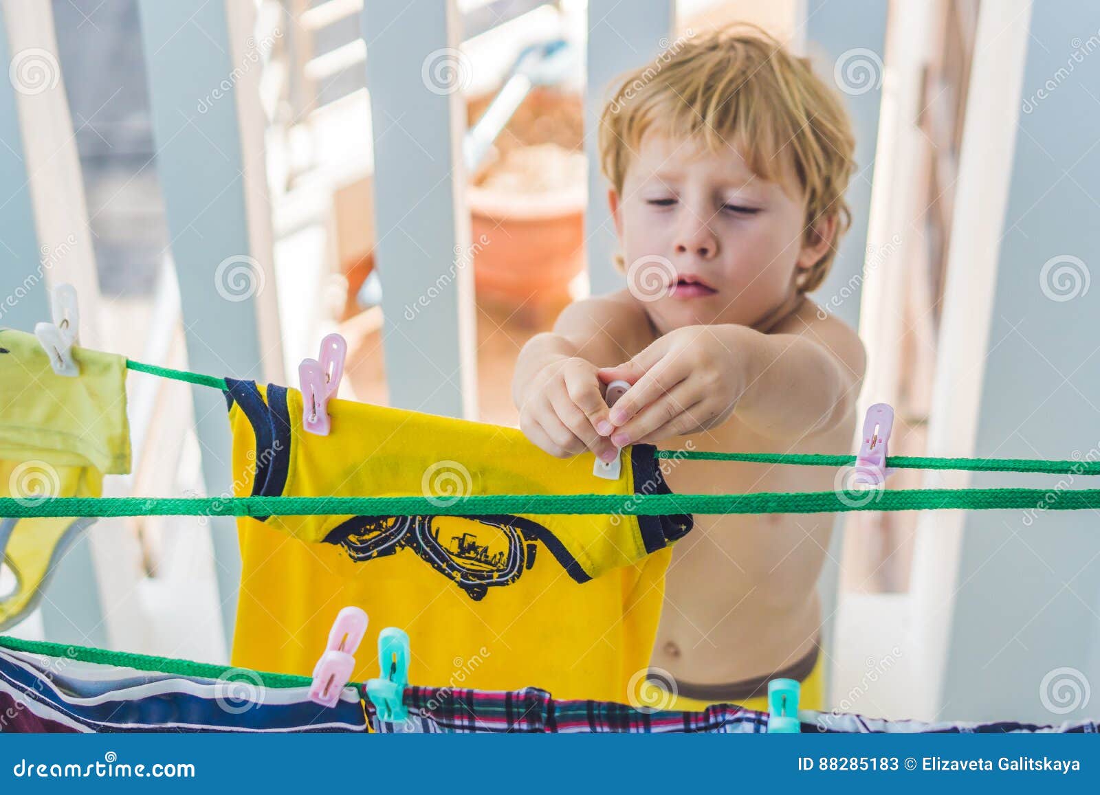 A Little Boy Helps Her Mother To Hang Up Clothes Stock Image - Image of ...