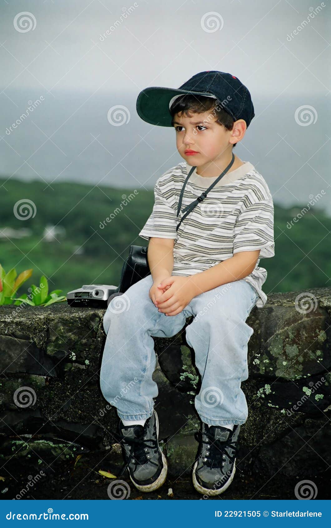 Little Boy infeliz con la cámara. Niño pequeño con y mirada triste, enojada o infeliz en su cara.