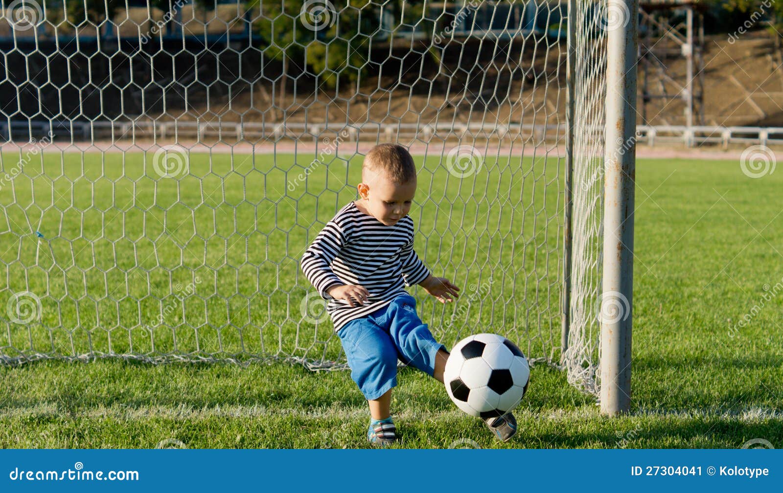 Little boy kicking a ball stock image. Image of little 27304041