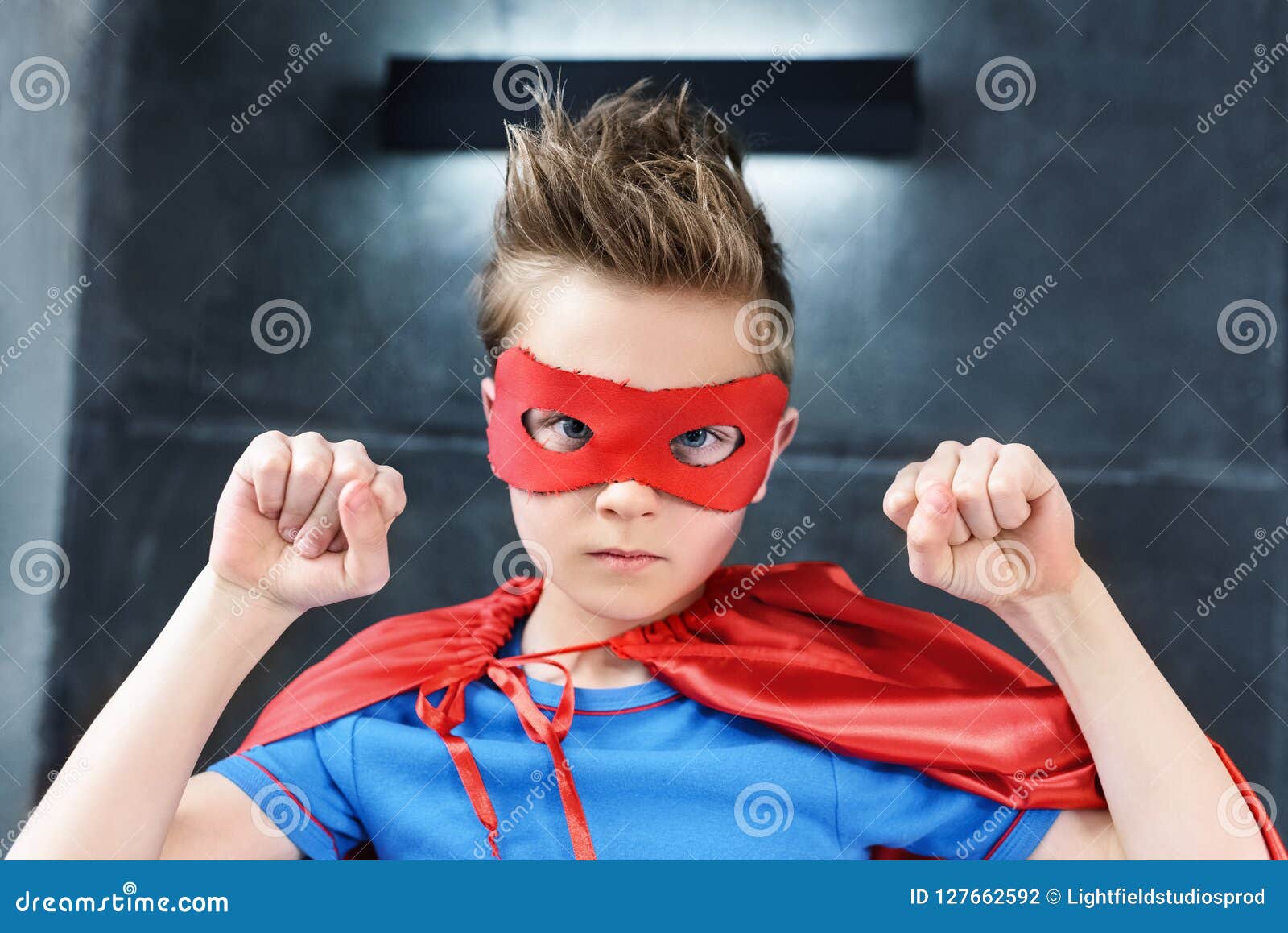 Little Boy in Red Superhero Costume Gesturing and Looking Stock Photo